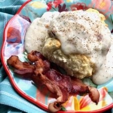 biscuits and gravy with bacon on a colorful plate