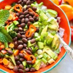 colorful veggies, black beans and avocado served over rice.