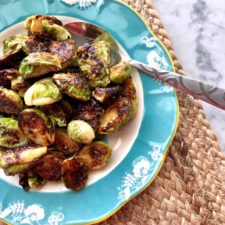 a blue bowl filled with honey mustard brussels sprouts