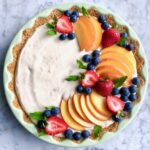 peach tart with berries in green dish