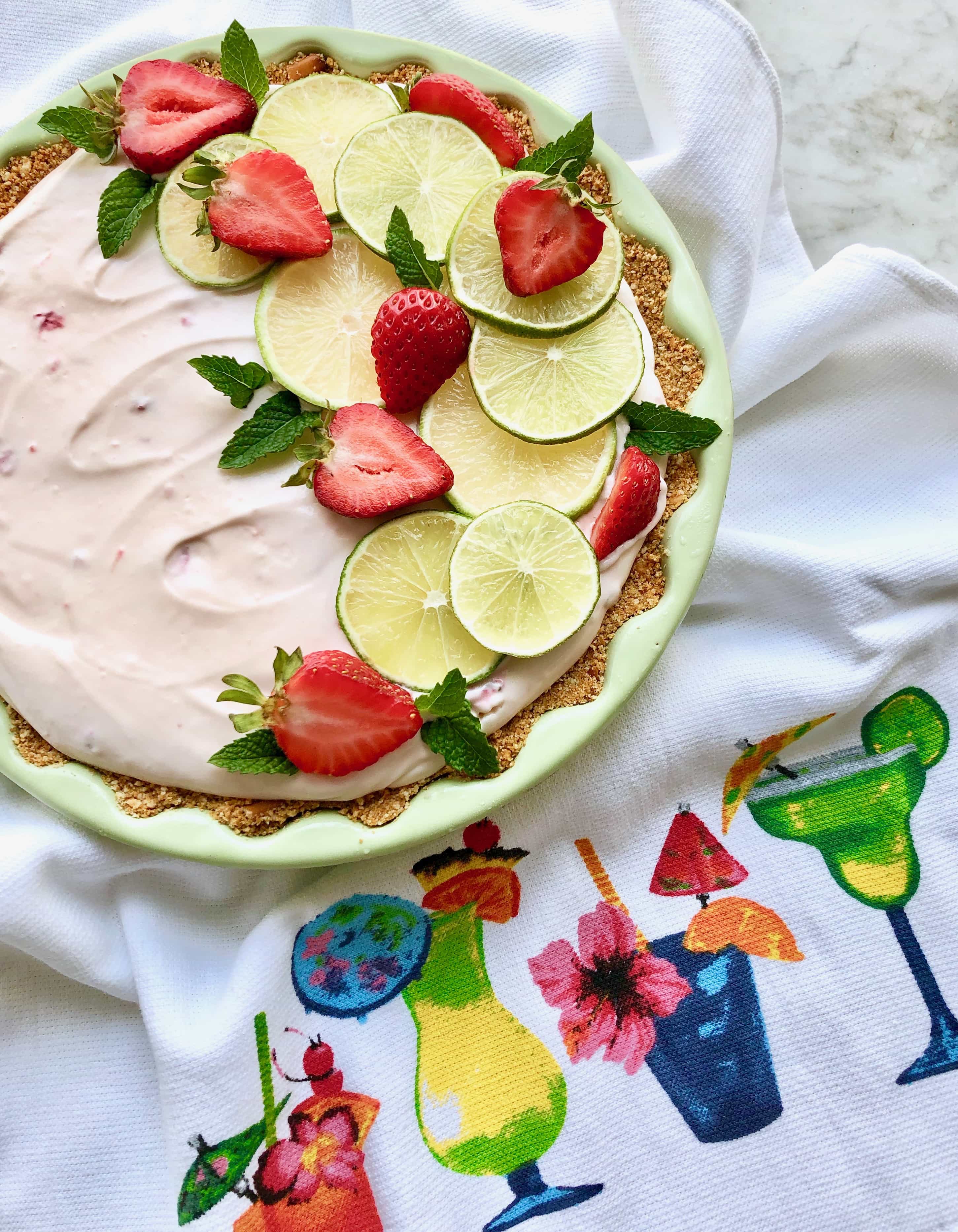 strawberry margarita pie on a colorful towel with cocktails on it