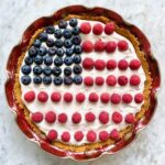 pie with flag decorations on top out of raspberries and blueberries