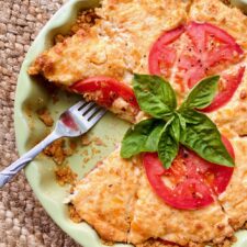 tomato pie with a slice missing and a fork left in its place