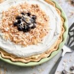 toasted coconut and chocolate on top of a coconut cream pie in a green plate.