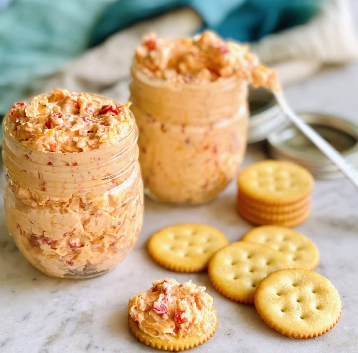 jars of southern pimento cheese with a blue background