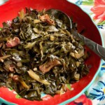 seasoned collard greens with bacon in a red bowl.