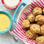 sausage balls in a red lined bowl with dips