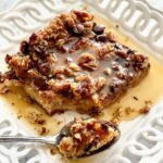 a slice of chocolate bread pudding on a white plate.