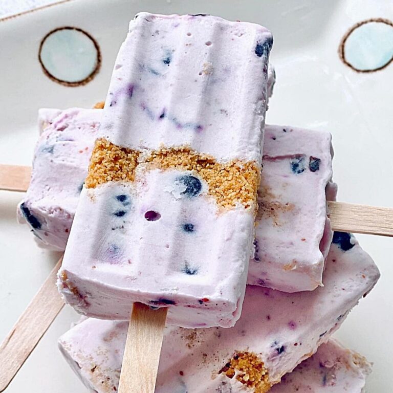 close up of a stack of blueberry cheese cake popsicles with graham crackers inside
