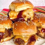 cheesy meatball sliders with bbq sauce on a white plate.