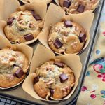 banana chocolate muffins in liners in a muffin tin pan.