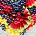 assorted fruit with a carved watermelon on a white platter