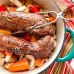 pork tenderloin over vegetables in a blue dutch oven.