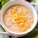 bowl of potato soup with cheese on top made in a dutch oven.