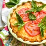 southern tomato pie garnished with fresh herbs and tomatoes.