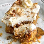 slice of carrot cake with a fork taking a bite.