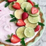 strawberry margarita pie with limes and strawberries on top.