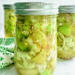 3 mason jars with green tomato pickles.