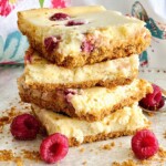 raspberry slab cheesecake bars in a stack on a table.