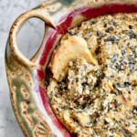 crostini dipped into baked spinach artichoke dip.