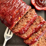 sliced smoked meatloaf with bbq glaze on the side.