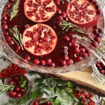 pomegranates floating with cranberries in a punch bowl.