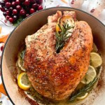 roasted turkey in a dutch oven with lemon and rosemary