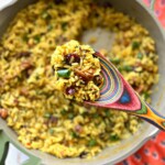 curry wild rice salad being served from a dutch oven.