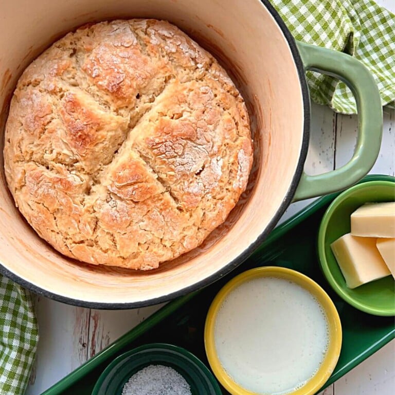 Irish soda bread in a green dutch oven with salt, buttermilk, butter, flour and baking soda..