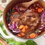 Guinness Pot Roast with carrots and cabbage in a dutch oven.