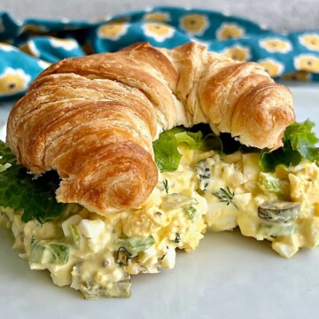 The best egg salad with pickles recipe on a toasted croissant.