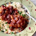 mango chicken breasts on top of angel hair pasta.