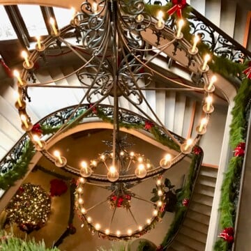 Grand Staircase decorated for Christmas at Biltmore with greenery and ribbons.