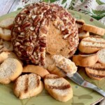 classic cream cheese ball being spread with a knife.