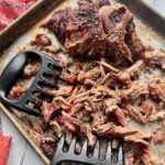 Traeger smoked pork butt being pulled apart with claws to make Traeger pulled pork.