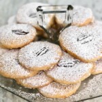 Cheddar cheese wafers with pecans and dusted powdered sugar.