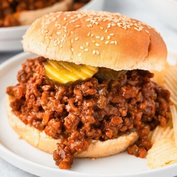 Old fashioned sloppy joes recipe with potato chips on a white plate.