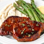 Honey glazed pork chops with mashed potatoes and asparagus.