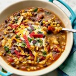 Mexican bean soup ready to serve in a blue bowl.