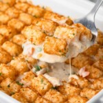 Tater tots being lifted up by a spatula in a casserole dish.