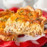 Breakfast quiche served out of red pie plate.
