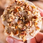 Pumpkin spice donut being held up with a hand.