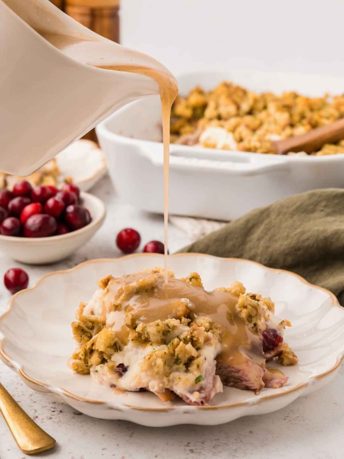 Gravy being poured on top of leftover turkey casserole.