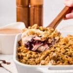 Wooden spoon lifting up a scoop of leftover turkey casserole.
