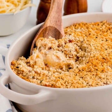 Vidalia onion casserole served in a white dish with a wooden spoon.