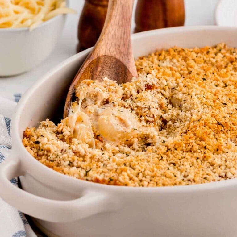 Vidalia onion casserole served in a white dish with a wooden spoon.