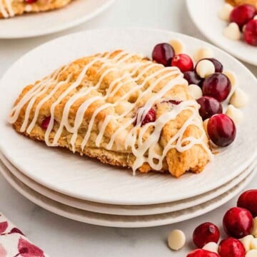 White chocolate cranberry scone ready to serve on white plates.