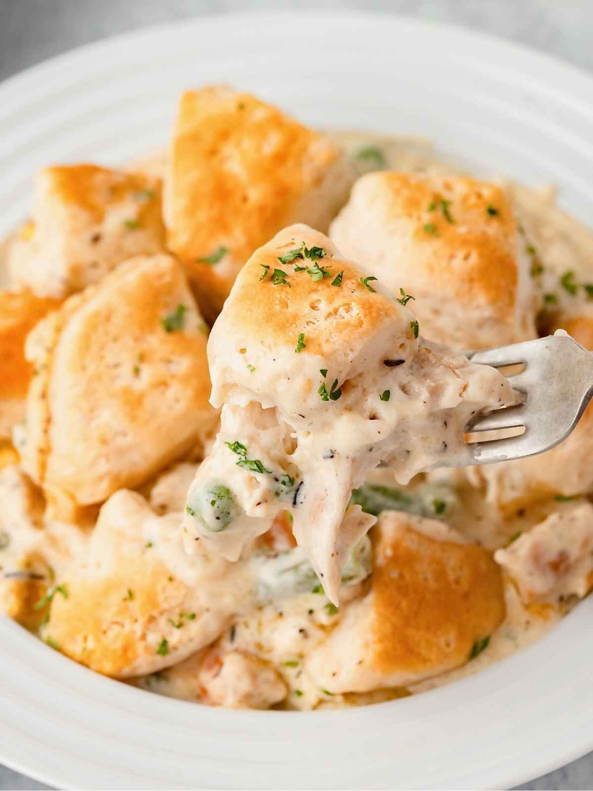 Fork holding up chicken and biscuits.
