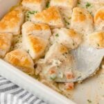 Chicken and biscuits being served with a spoon.