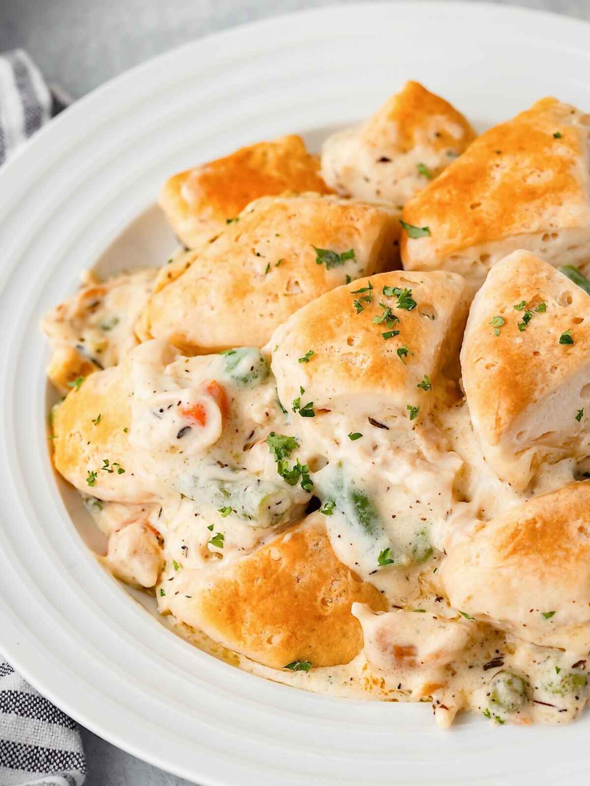 Bowl full of chicken and biscuits.